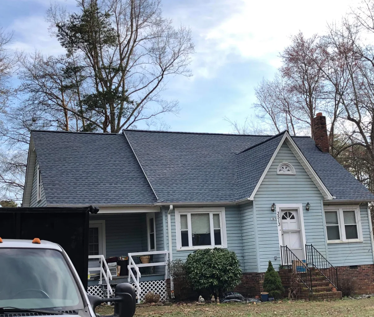 A light blue house with a newly installed dark gray roof